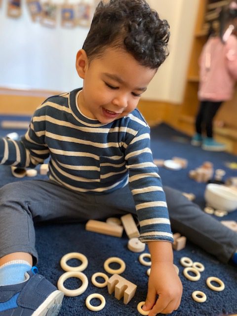 Child playing with wooden rings